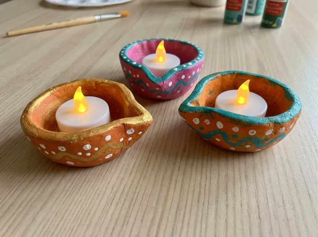 Painted clay diyas holding battery LED tea lights